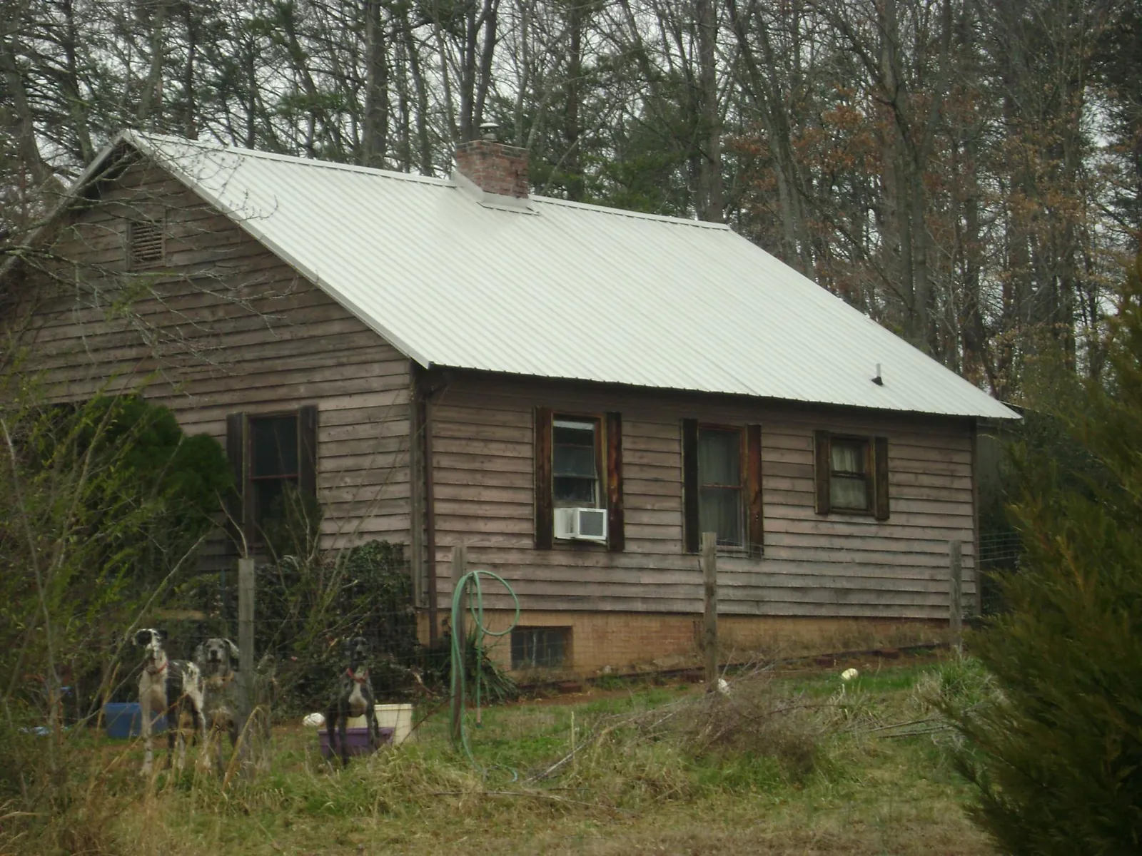 White metal roof on an old wood sided farmhouse, from a Metal Roof Installation job in Wanette